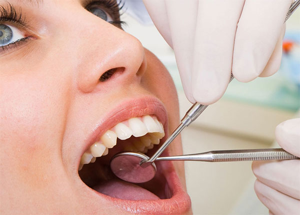 Clínica Dental Dr. Andrés García Díaz odontologo examinando dentadura de mujer